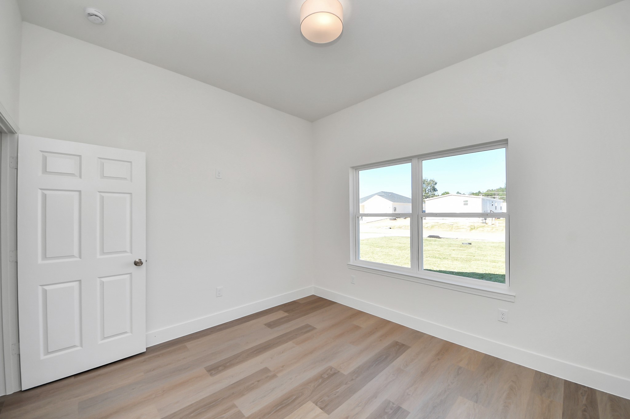 16280 Jeet Street Conroe, TX 77306 - Photo 35 of 44 an empty room with wooden floor and windows