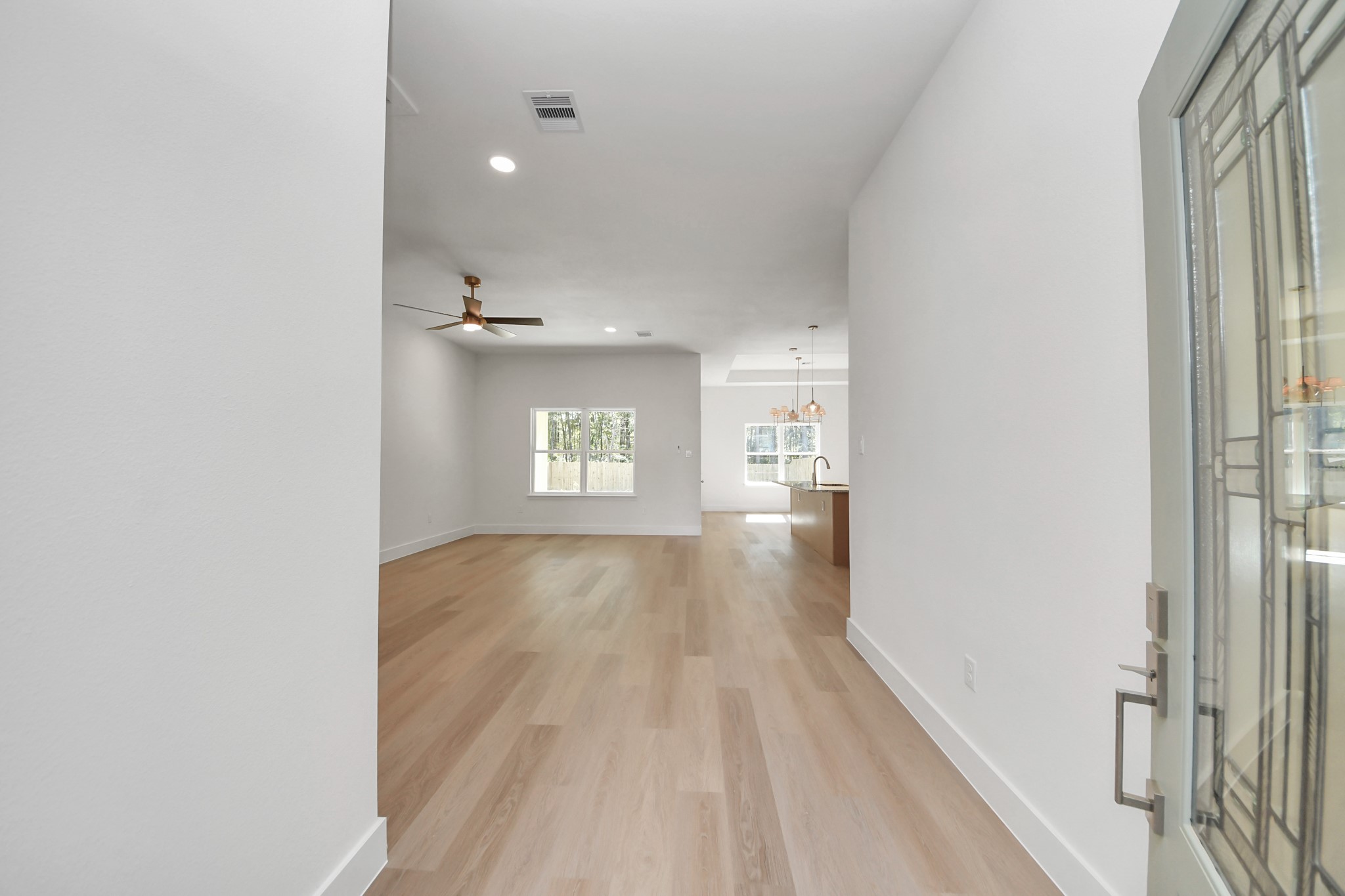 16280 Jeet Street Conroe, TX 77306 - Photo 4 of 44 a view of a hallway with wooden floor and a living room