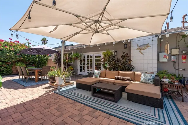 a view of a patio with a table and chairs under an umbrella