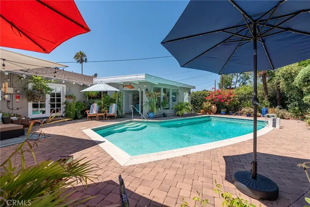 a view of a yard with table and chairs under an umbrella