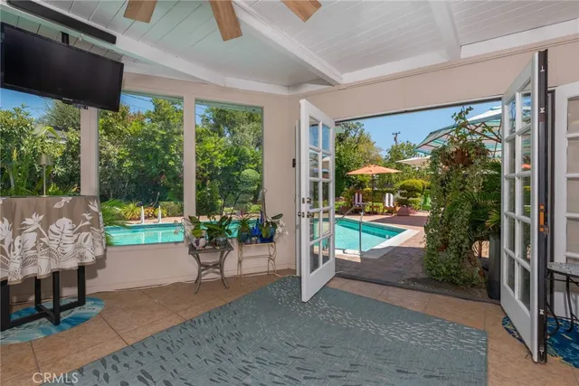 a view of a patio with table and chairs potted plants with floor to ceiling window