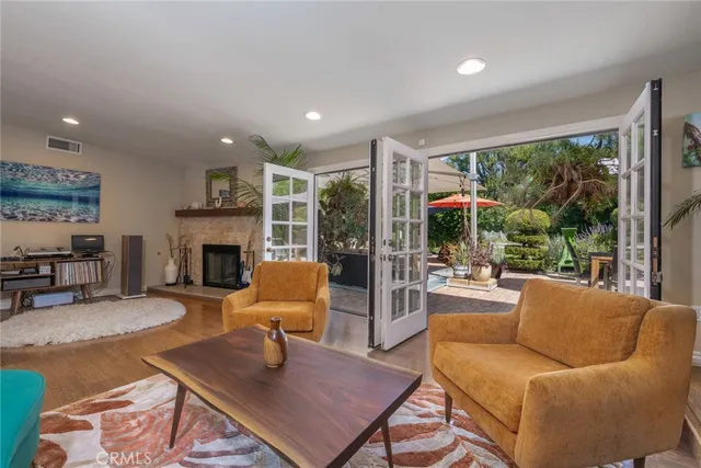 a living room with furniture a fireplace and a floor to ceiling window