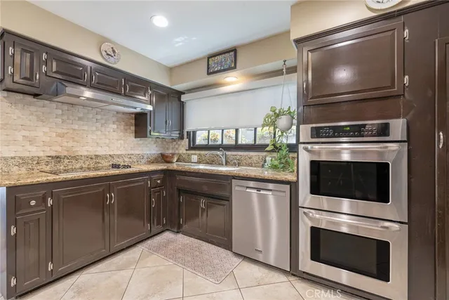 a kitchen with stainless steel appliances granite countertop a stove microwave and refrigerator