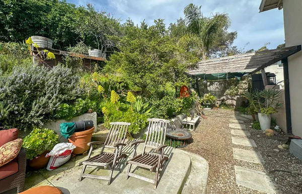 a view of backyard with seating space and trees