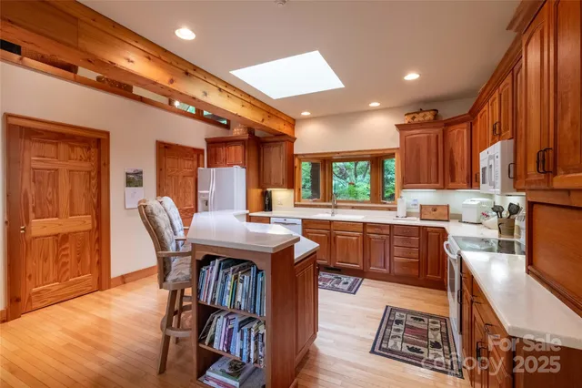 a open kitchen with a table chairs and a refrigerator