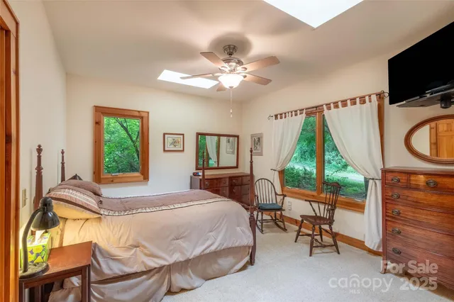 a bedroom with a bed a flat screen tv and a window