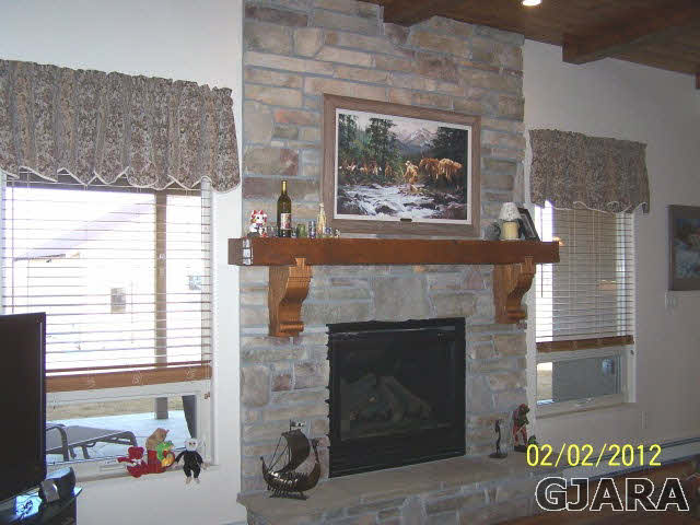 1682 14 Road Loma, CO 81524 - Photo 11 of 27 a living room with a fireplace wooden floor and a fireplace