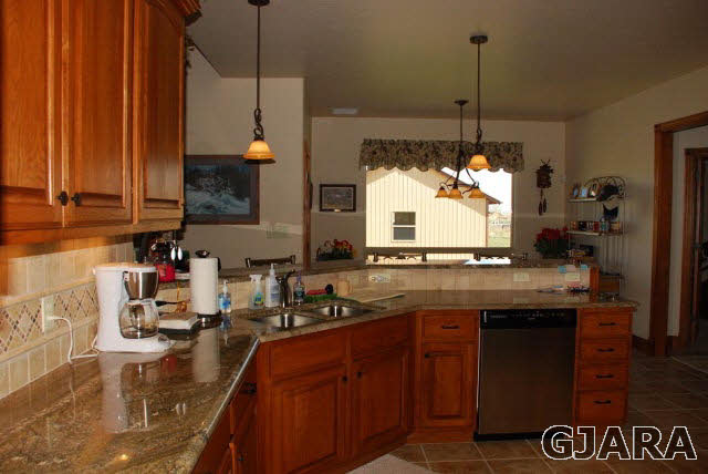 1682 14 Road Loma, CO 81524 - Photo 7 of 27 a kitchen with kitchen island granite countertop a sink a stove and a wooden floors