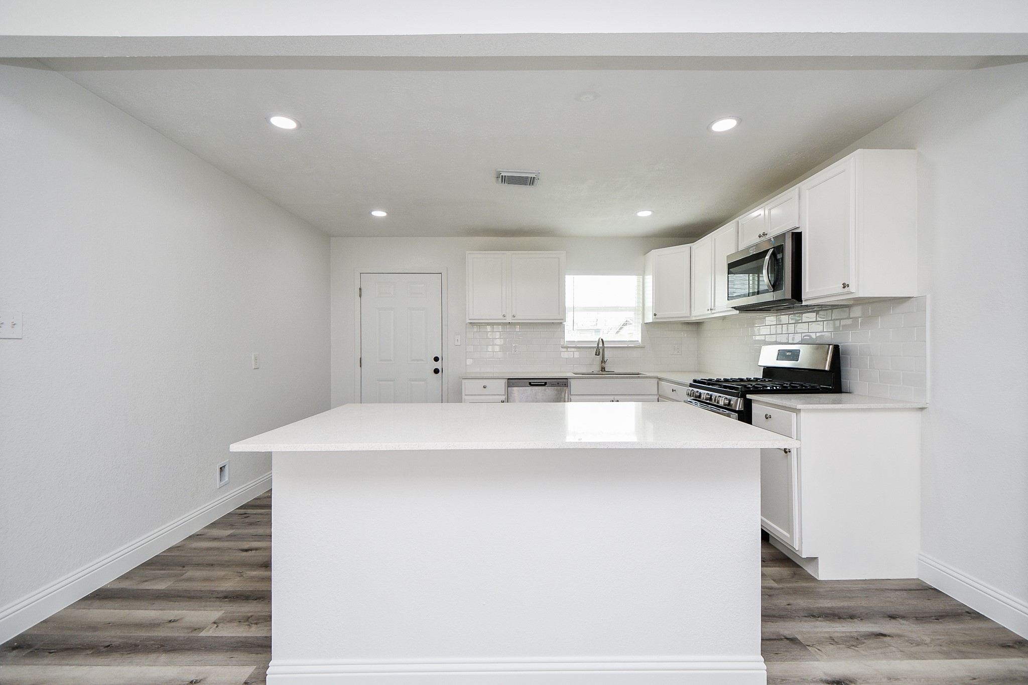 5814 Belneath Street Houston, TX 77033 - Photo 12 of 32 a kitchen with stainless steel appliances a sink a stove a refrigerator cabinets and a window