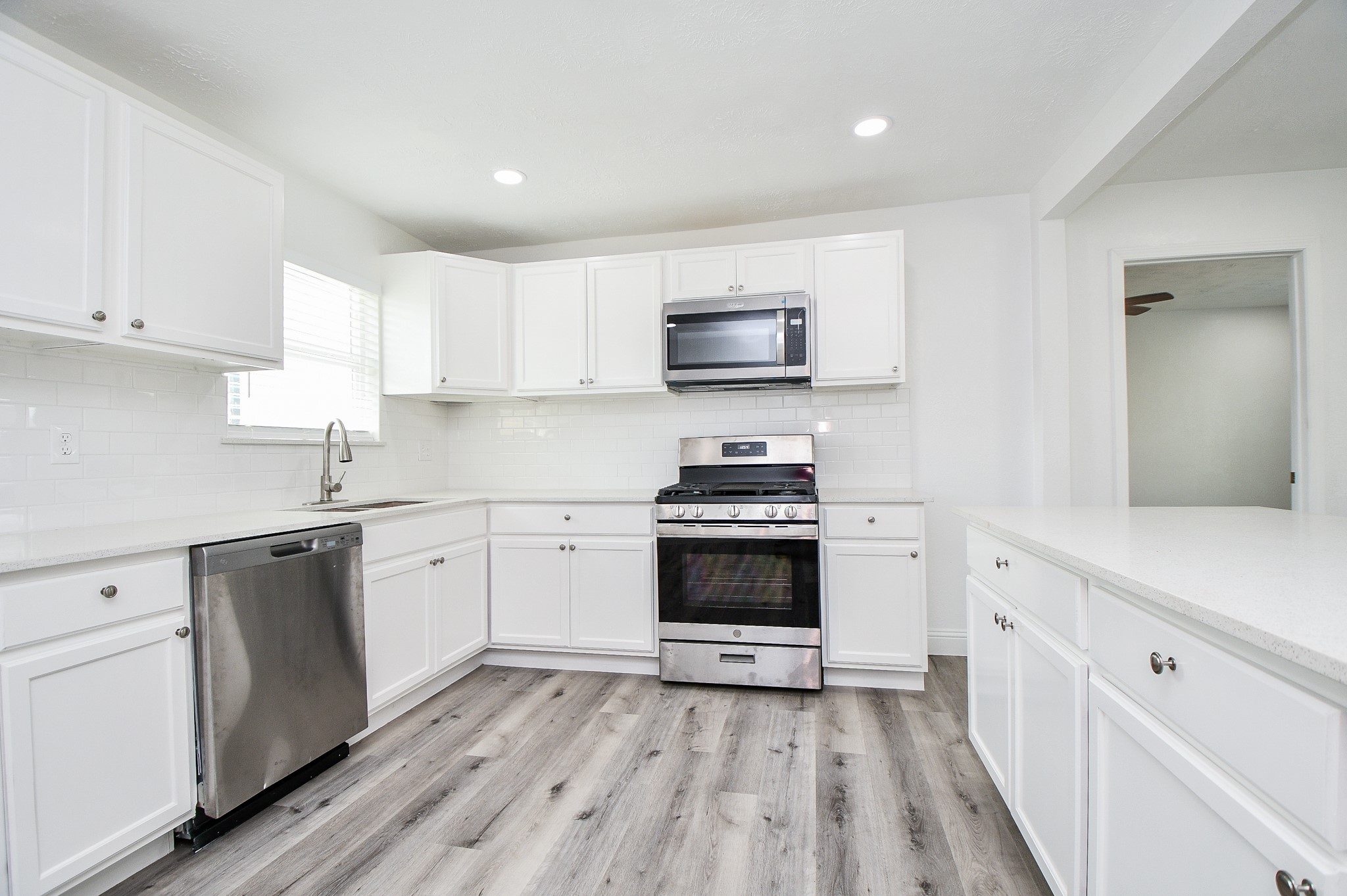 5814 Belneath Street Houston, TX 77033 - Photo 14 of 32 a kitchen with a sink a stove and cabinets