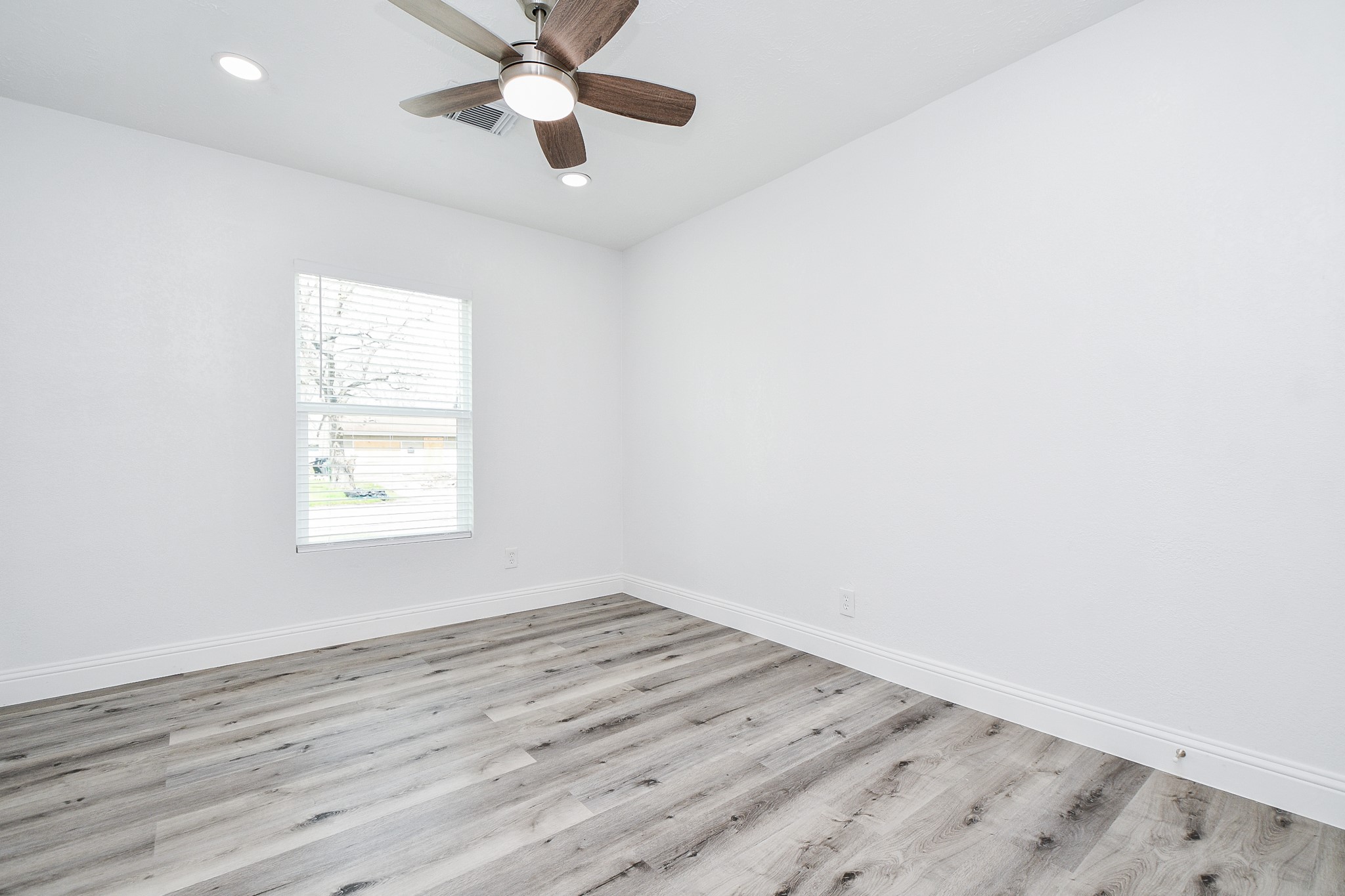 5814 Belneath Street Houston, TX 77033 - Photo 23 of 32 an empty room with a window and a ceiling fan