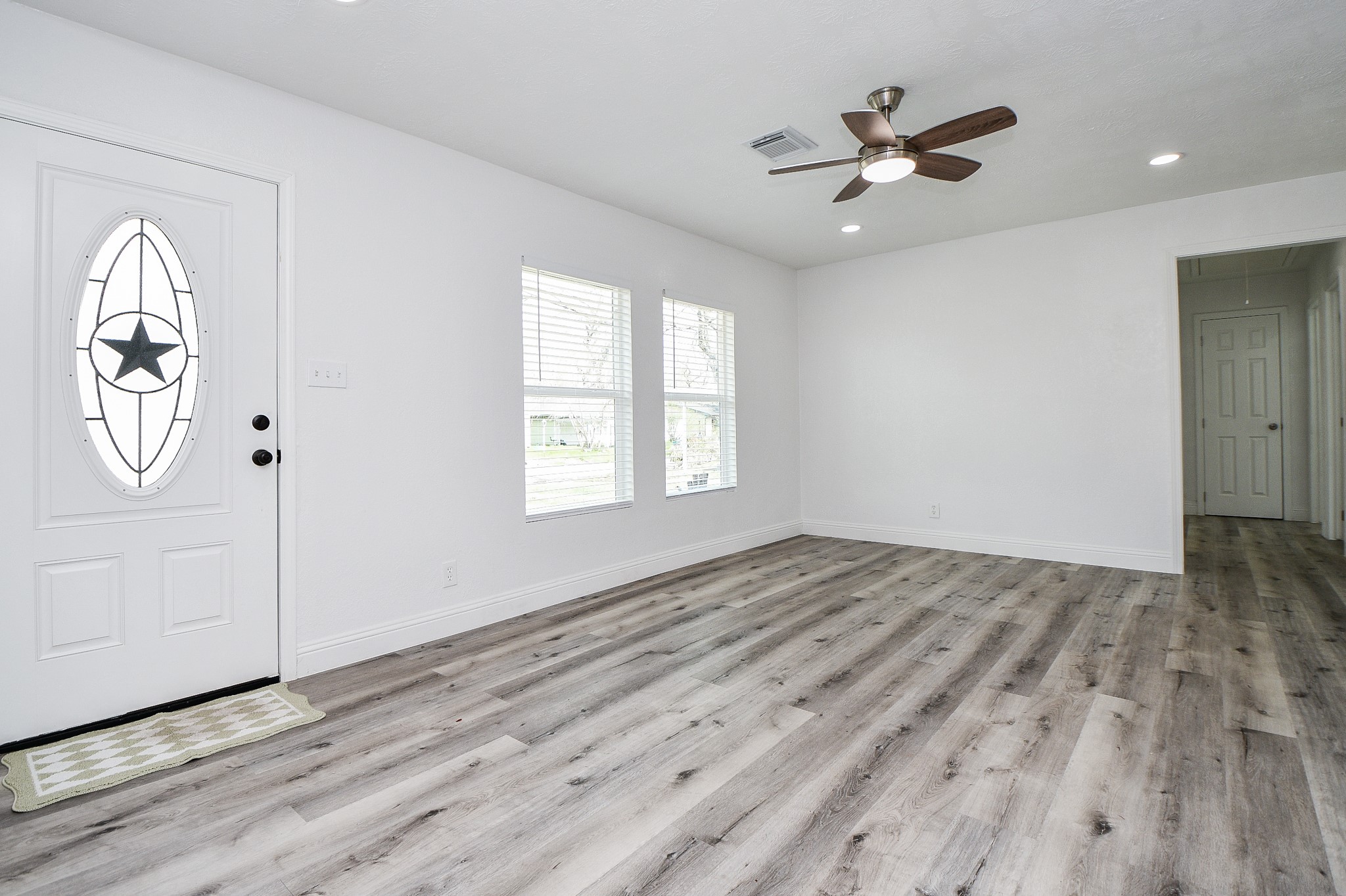 5814 Belneath Street Houston, TX 77033 - Photo 8 of 32 an empty room with wooden floor cabinet and windows