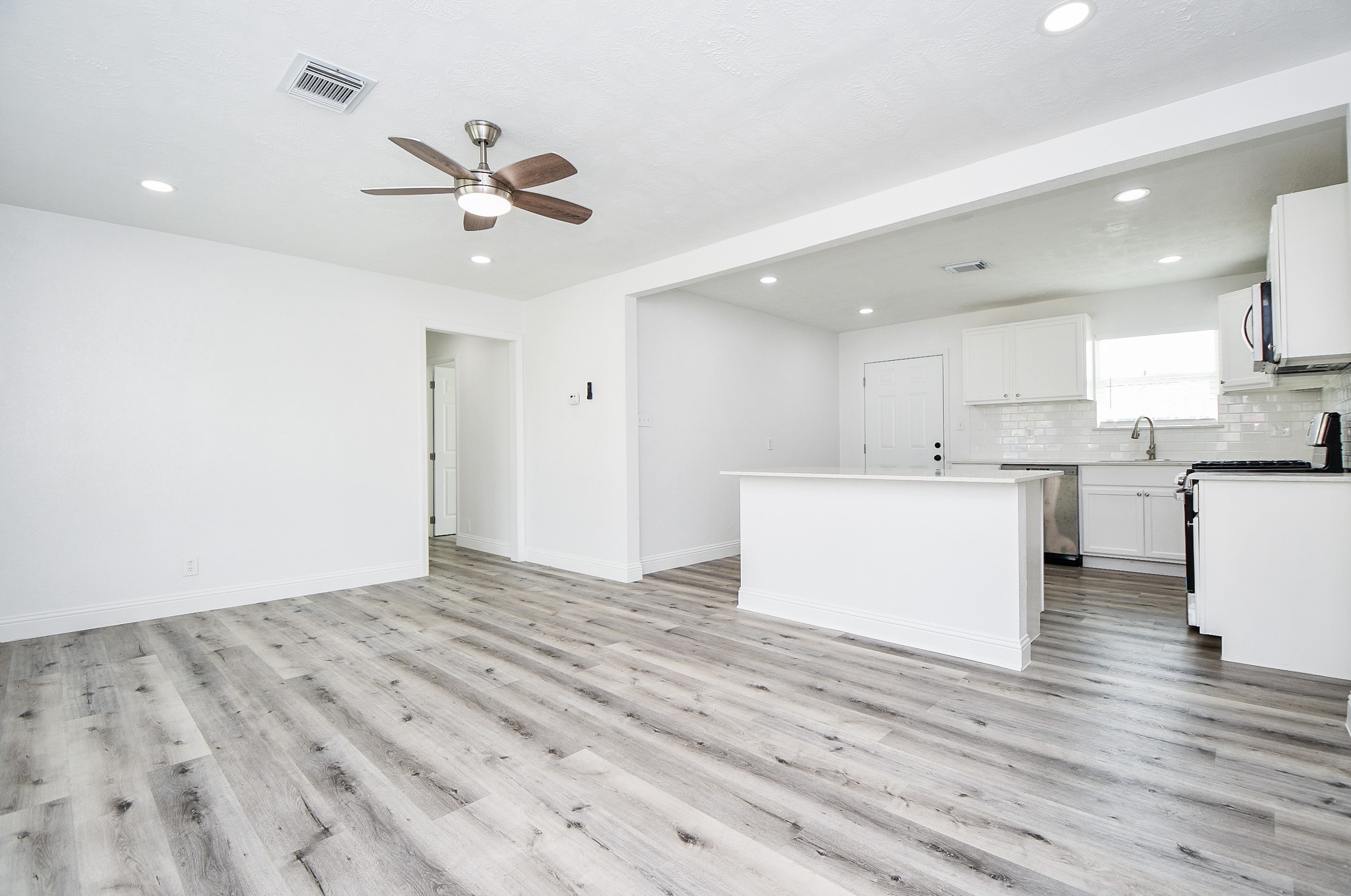 5814 Belneath Street Houston, TX 77033 - Photo 9 of 32 a view of a kitchen with wooden floor and window