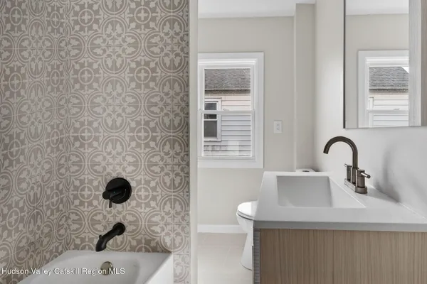 a bathroom with a sink a toilet and a mirror