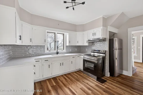 a kitchen with stainless steel appliances granite countertop a stove a sink and a refrigerator