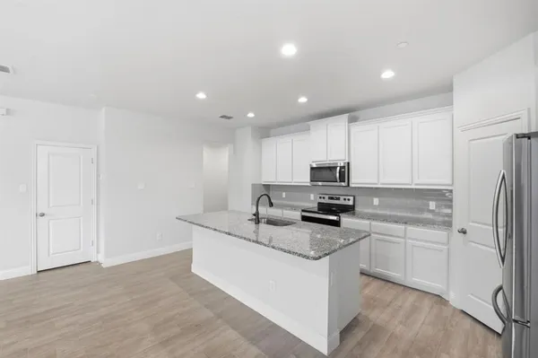 a kitchen with a sink stove and refrigerator