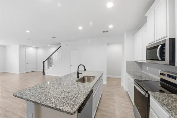 a kitchen with sink stove and kitchen island