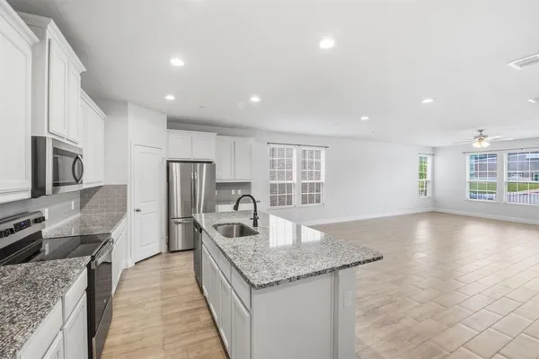 a kitchen with stainless steel appliances granite countertop a sink dishwasher stove and refrigerator