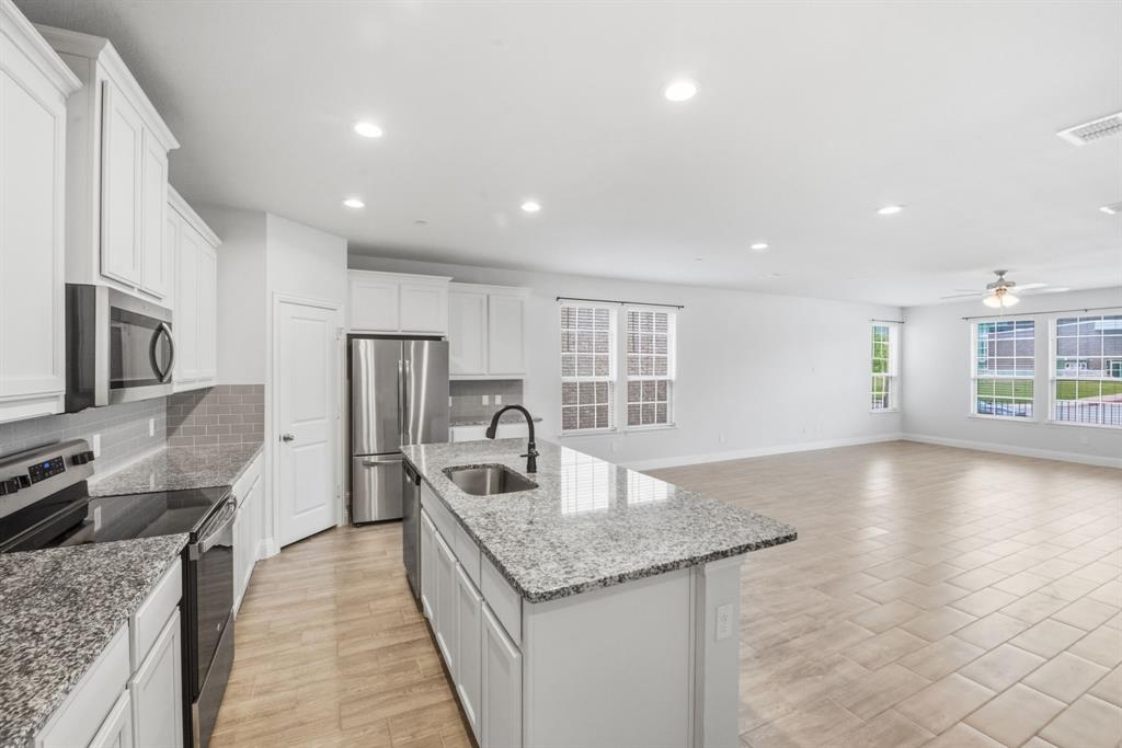 5960 Bursey Road Watauga, TX 76148 - Photo 17 of 38 a kitchen with stainless steel appliances granite countertop a sink dishwasher stove and refrigerator