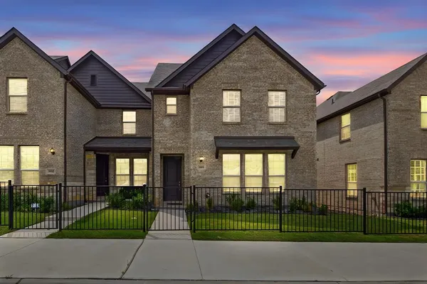 a front view of a house with a garden and plants