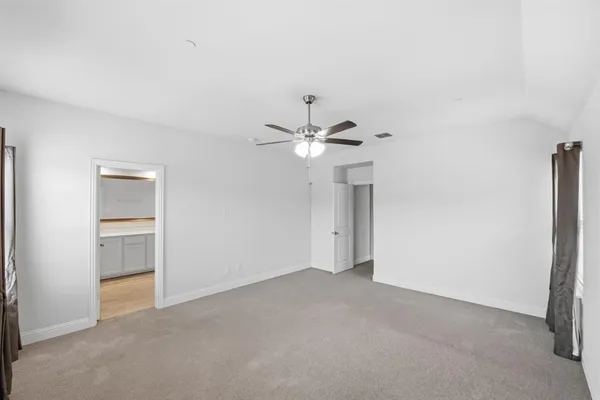 a view of an empty room with a ceiling fan