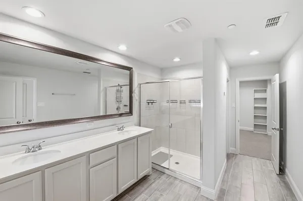 a spacious bathroom with a shower sink and mirror