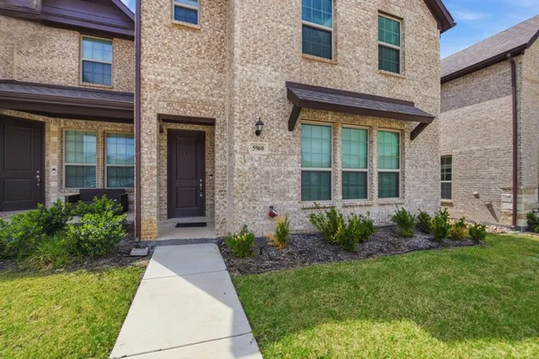 a front view of a brick house with a yard