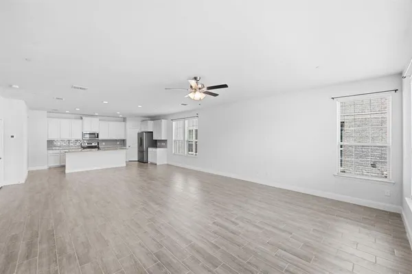 a view of a kitchen with cabinets and wooden floor