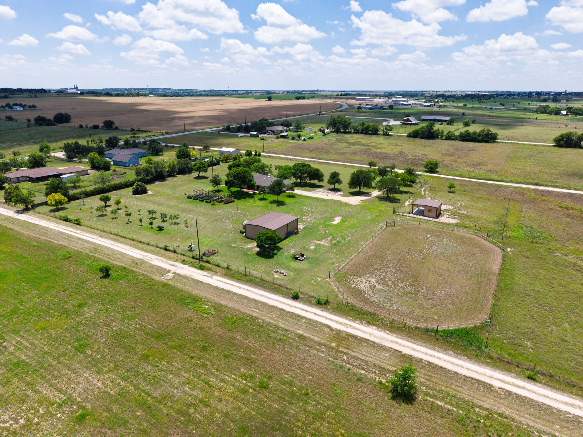 120 Rae Lane Jarrell, TX 76537 - Photo 8 of 40 Expansive rural property featuring an unpaved road, multiple buildings, and agricultural fields