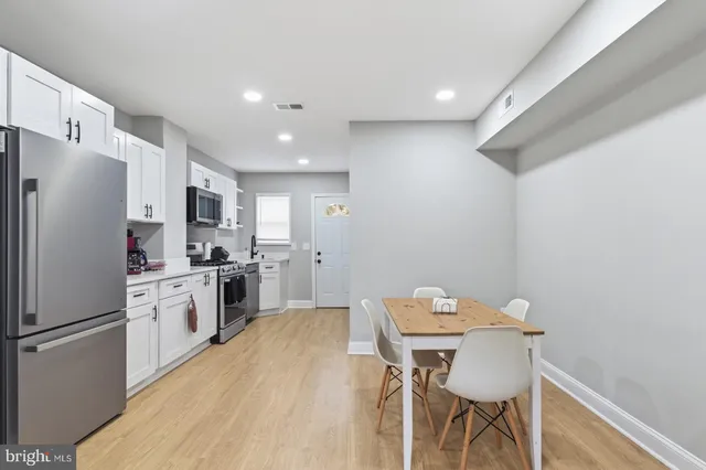 a kitchen with a refrigerator a table and chairs