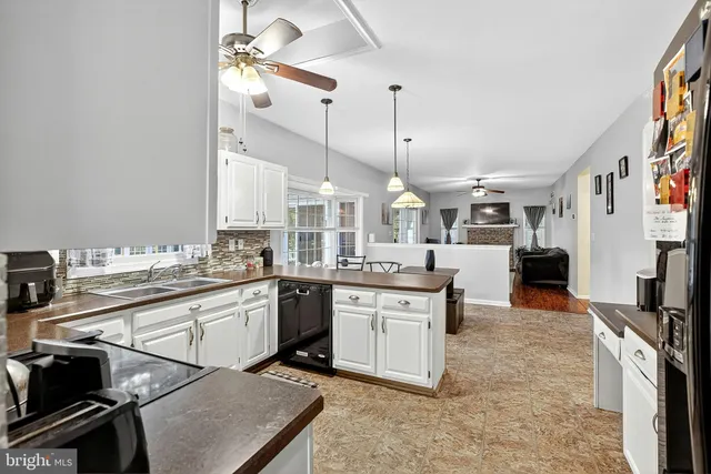 a living room with stainless steel appliances granite countertop furniture and a kitchen view