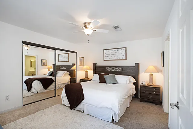 a spacious bedroom with a bed and glass door