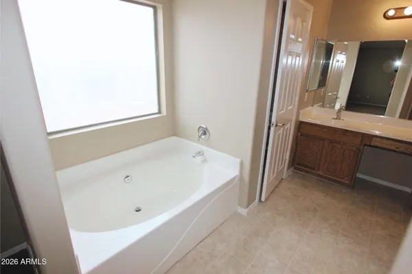 an empty room with a bathroom and a chandelier fan