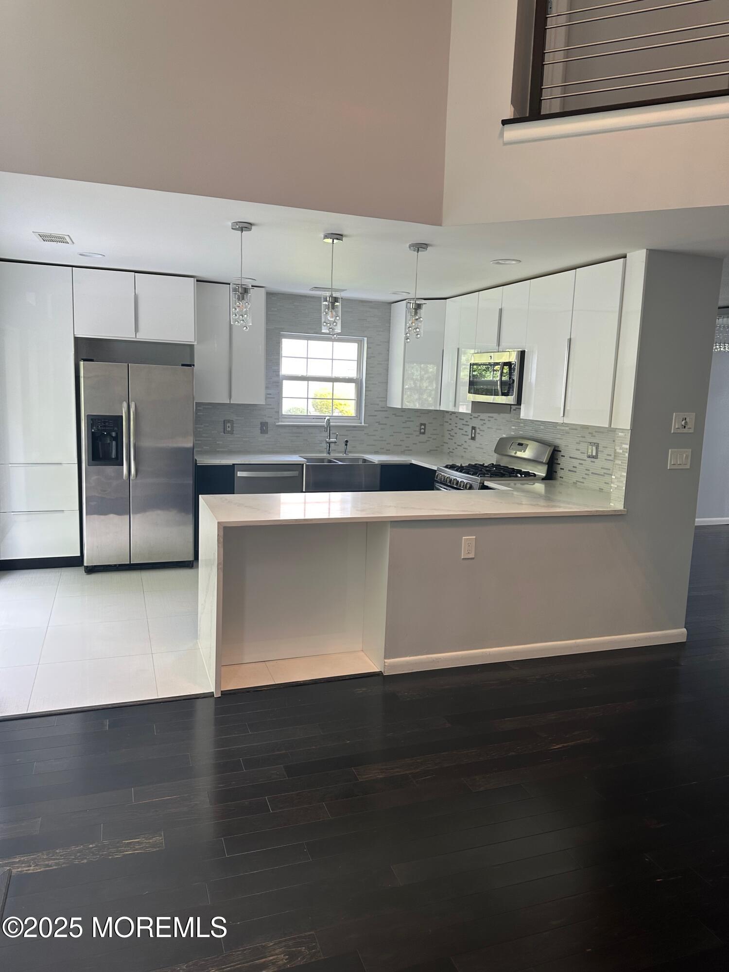 36 Alpine Road, Unit 169 Holmdel, NJ 07733 - Photo 6 of 19 a large white kitchen with stainless steel appliances a sink a stove a microwave a counter top and a refrigerator