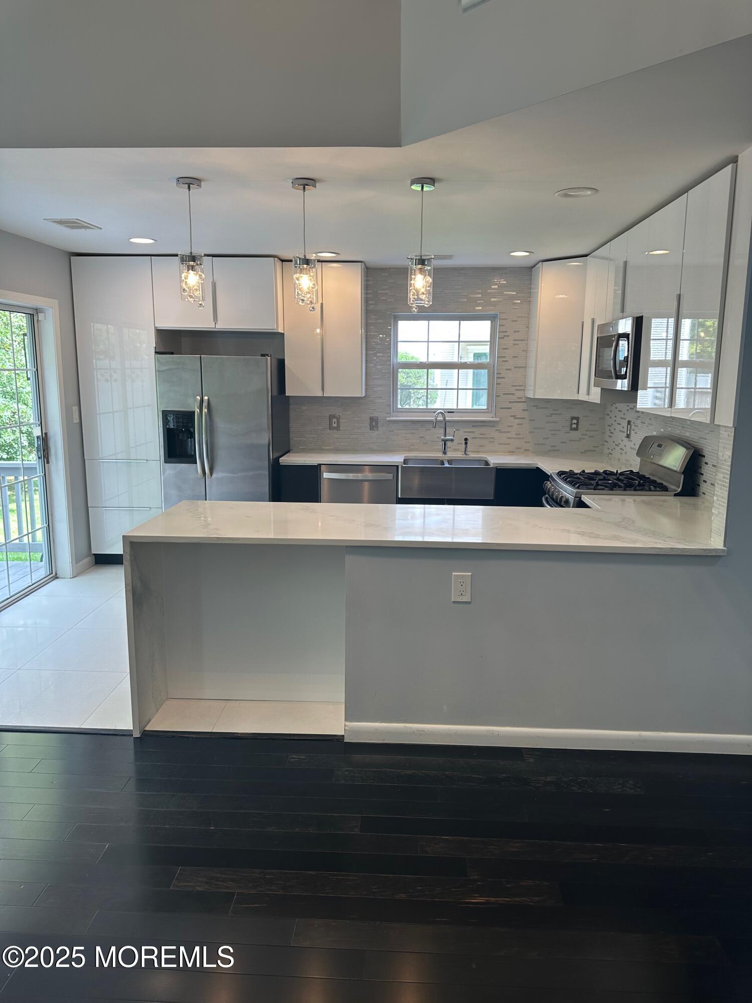 36 Alpine Road, Unit 169 Holmdel, NJ 07733 - Photo 7 of 19 a kitchen with a sink dishwasher a stove and a microwave oven