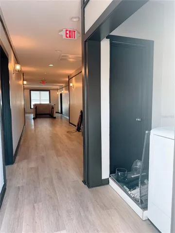 a view of a hallway to an empty room and a bathroom