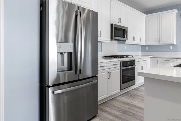 a kitchen with stainless steel appliances a refrigerator stove and microwave
