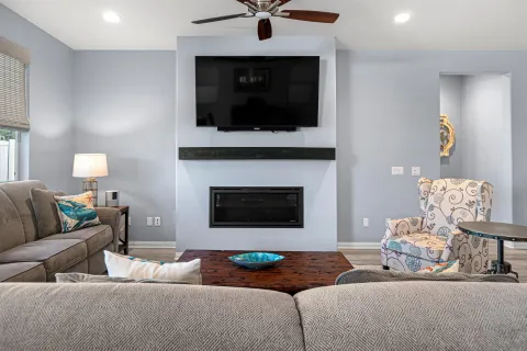 a living room with furniture kitchen view and a flat screen tv