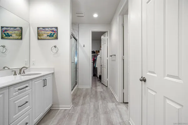 a spacious bathroom with a granite countertop sink a mirror a vanity and a shower