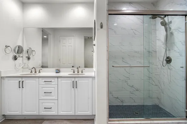 a bathroom with a granite countertop sink a mirror and shower