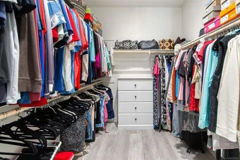 a view of a hallway with wooden floor and closet area