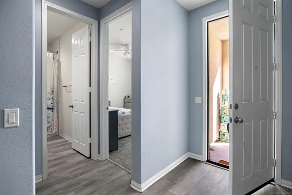 a view of a hallway with wooden floor and closet area