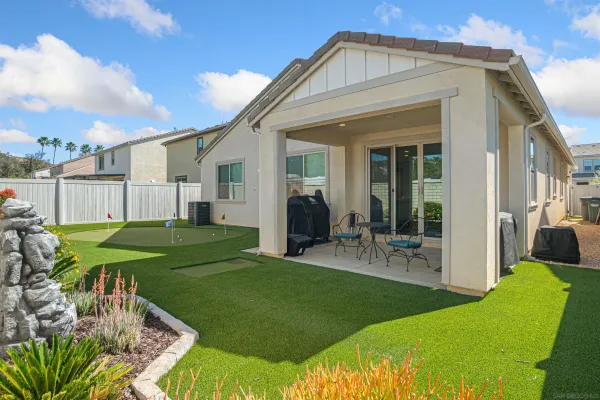a view of a house with backyard and sitting area