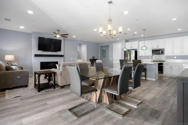 a view of kitchen with microwave refrigerator dining table and chairs