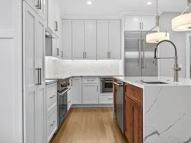 a kitchen with stainless steel appliances granite countertop a refrigerator and a sink