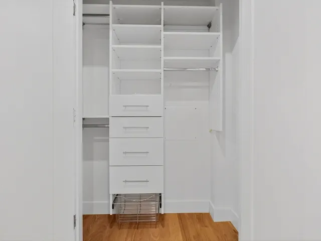 a view of walk in closet with empty racks