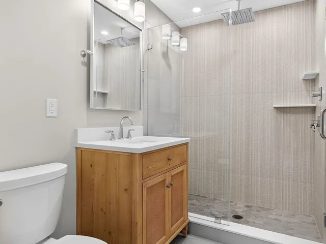 a bathroom with a sink a toilet and shower
