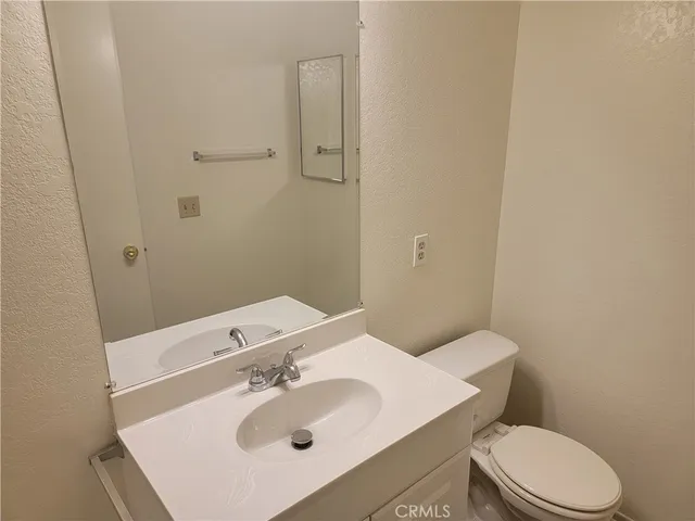 a bathroom with a sink a toilet and mirror