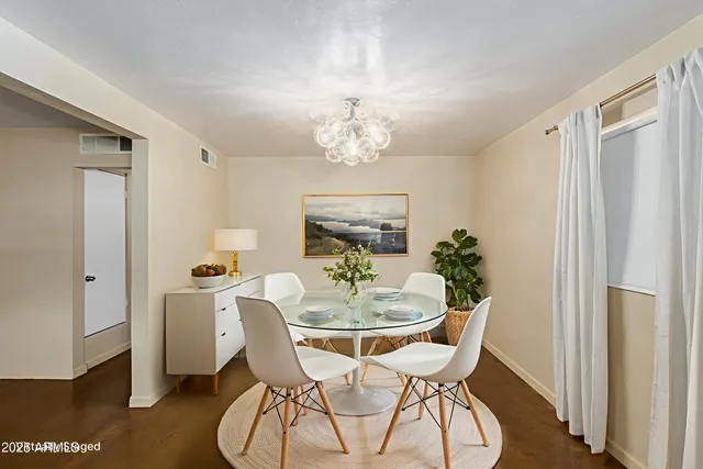 a dining room with furniture a chandelier and wooden floor