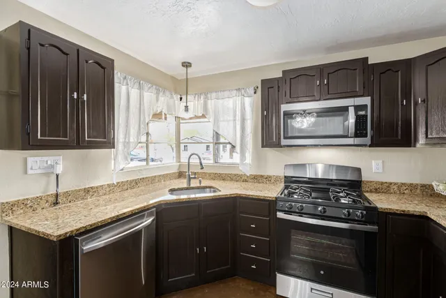 a kitchen with stainless steel appliances granite countertop a stove microwave and cabinets